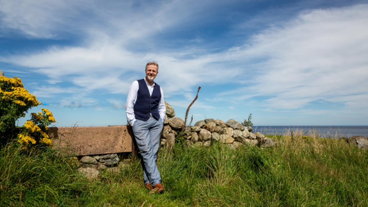 Michael Londra standing in front of stone wall in Ireland