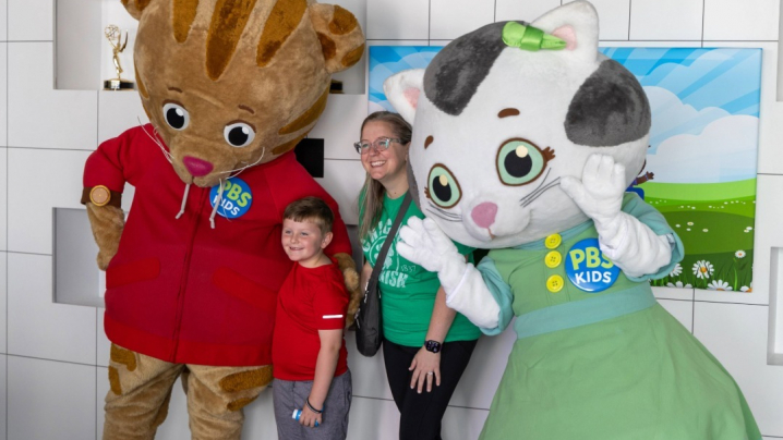 Adult woman and young boy posing with live-action Daniel Tiger and Katerina Kittycat
