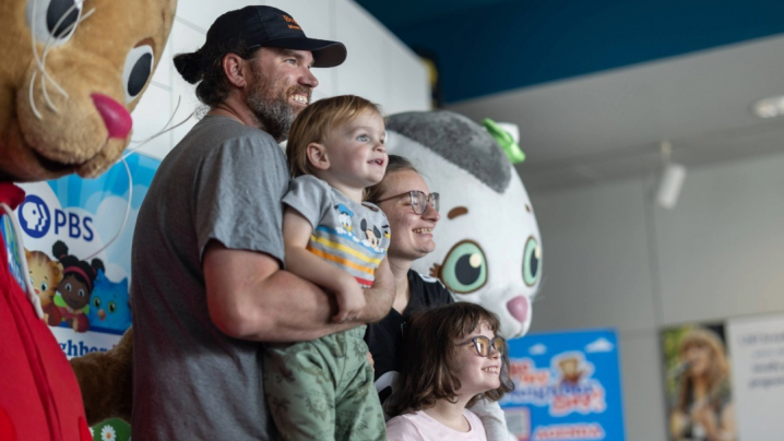 Family posing for a photo with Daniel Tiger and Katerina Kittycat