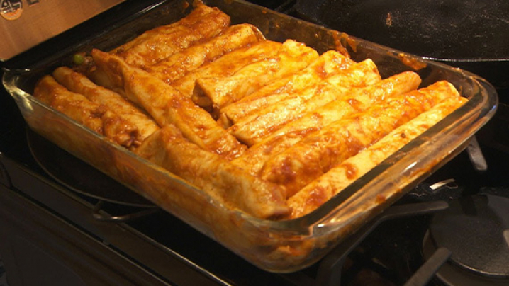 A steaming pan of lasagna sits on the stovetop.