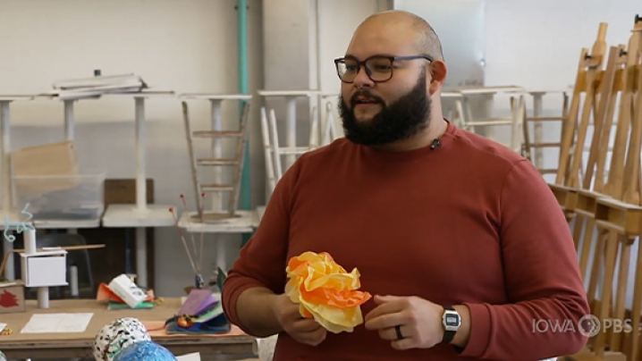 Eduardo Bolaños holds a paper marigold.