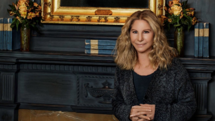 Barbra Streisand standing in front of fireplace