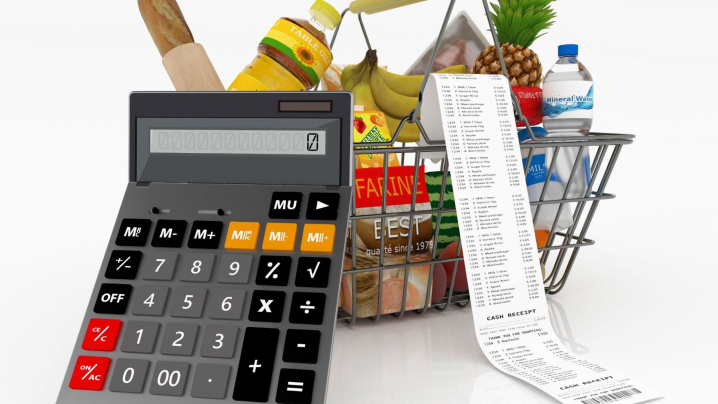calculator in front of grocery basket filled with food