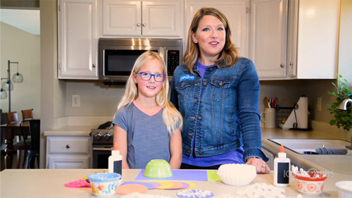 Abby and her friend get ready to make snowflakes for a snowflake party.