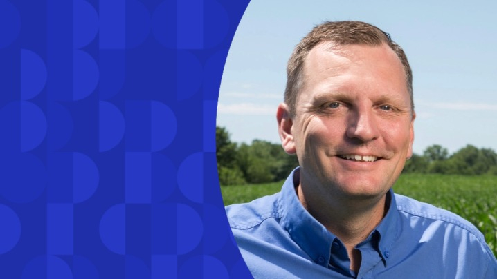 A man in a blue shirt standing outside.