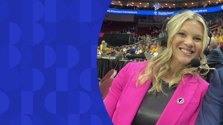 A woman in a pink blazer and a headset on.