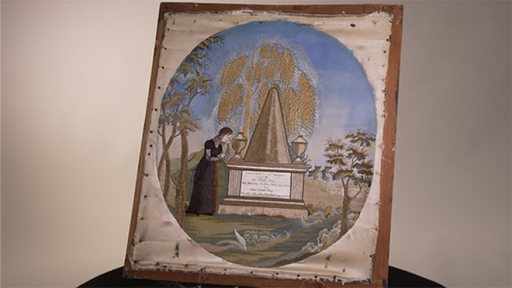 A framed example of a Revolutionary War Era Mourning Embroidery.