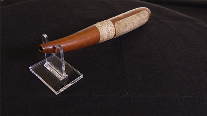 A Revolutionary War powder horn made from a reddish-brown gourd.