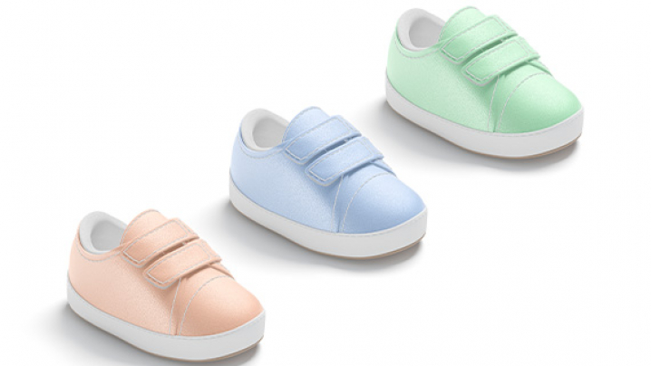 Three pairs of children's sneakers in peach, light blue, and pastel green, featuring Velcro straps and white soles.