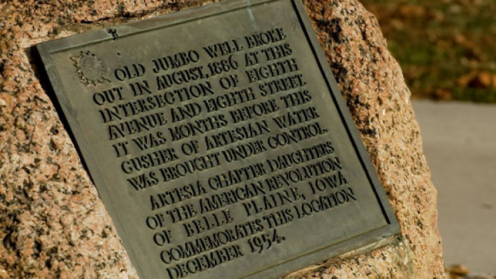 Bronze plaque on a textured rock, commemorating the Old Jumbo Well and its historical significance from 1866.