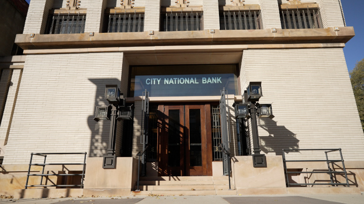 An entrance with a glass window above that reads City National Bank.