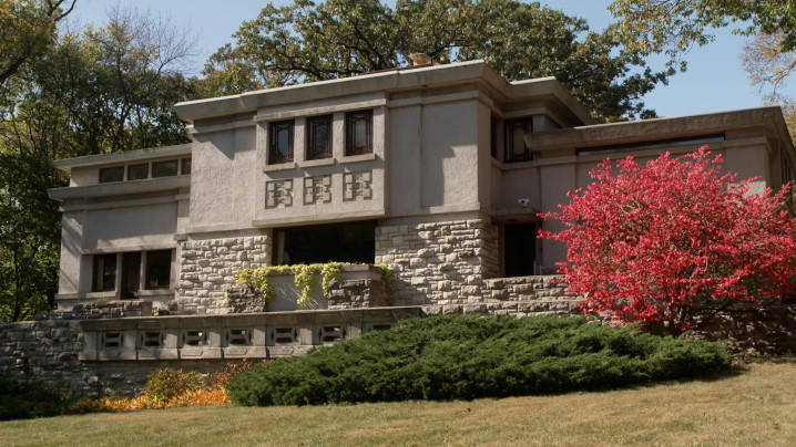 A house designed with horizontal lines, a flat roof with stucco and stone finishes.