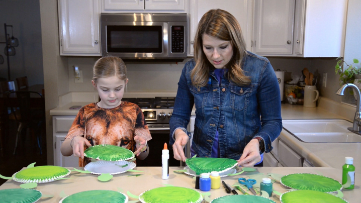 Host Abby Brown and a young girl creating Yertle the Turtle crafts together