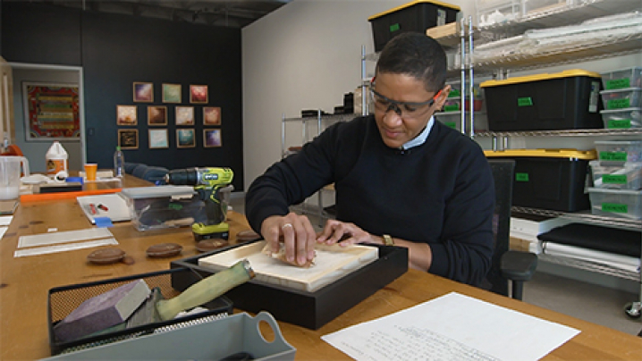 Artist, Jill Wells works on braille artwork in her studio.