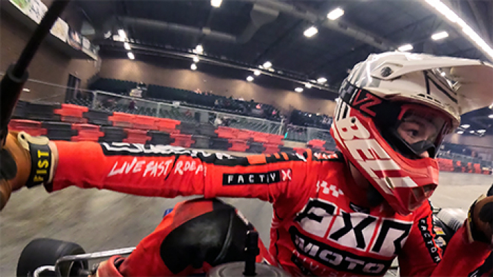 An onboard view of a racer as they turn the corner of an indoor track.