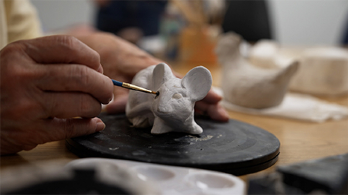 A small ceramic mouse is painted.