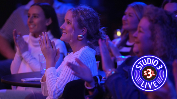 4 women clapping while watching a music performance