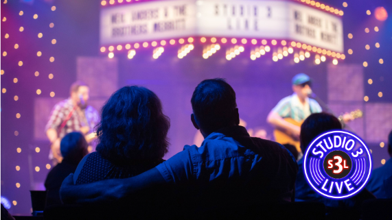 Two people watching a band perform.