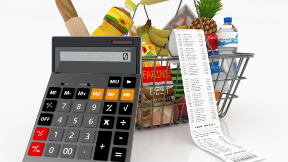 calculator in front of grocery basket filled with food