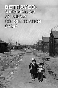 A small girl and boy walking down a dirt walkway at at concentration camp.