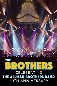 The Allman Brothers perform onstage under the lights.