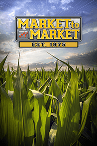 Market to Market - Est. 1975 logo in the sky over a field of corn stalks.