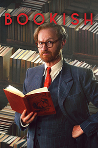 Bookish show title in red, above a sharply-dressed (in a three piece suit and red tie) character Gabriel Book. He is holding a book with a red cover titled, "Cataracts of the Nile." In the background are rows and rows of books.