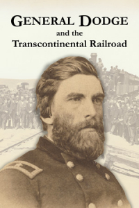 In the foreground is a man in a military uniform. Behind a large crowd is gathered along train tracks and a locomotive.
