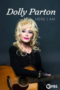 Dolly Parton holds a guitar.