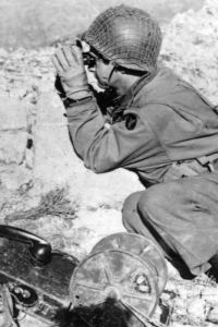 An Iowa soldier, part of the 34th Division, looking through binoculars in North Africa in 1943.