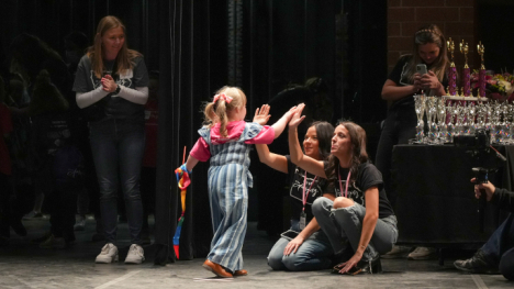 High fives between participant and director at Iowa Miss Amazing