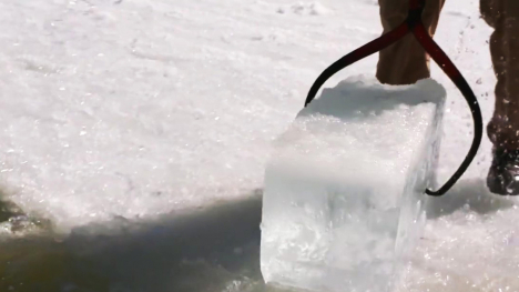 A block of ice being pulled from a frozen river.