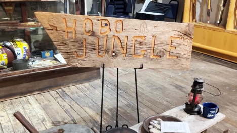 A rough-carved, wooden sign reading "Hobo Jungle."