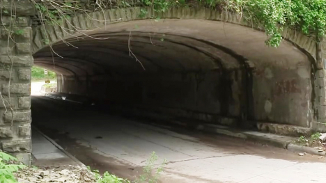 A dark tunnel which is intended for cars to drive through.