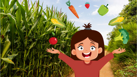 Young girl displays food grown in Iowa with a corn field in the background
