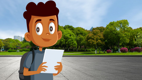 Young boy stands on a park blacktop with a forest in the background