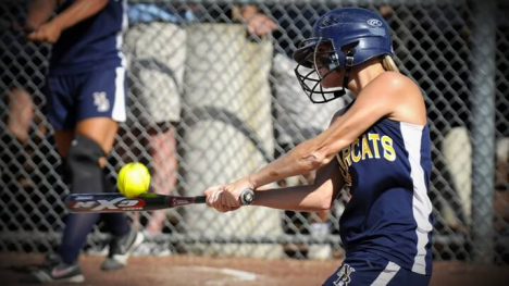 Softball player swinging her bat