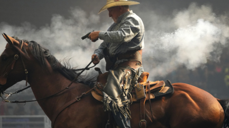 man atop a horse actively participating in mounted shooting