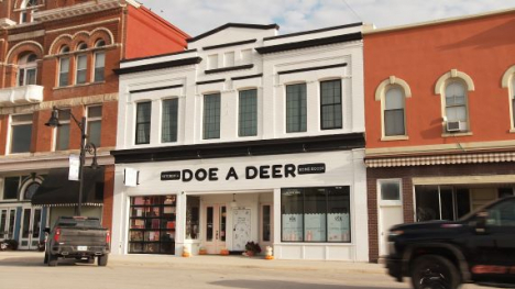 A white building store front with the words Doe A Deer above the doors