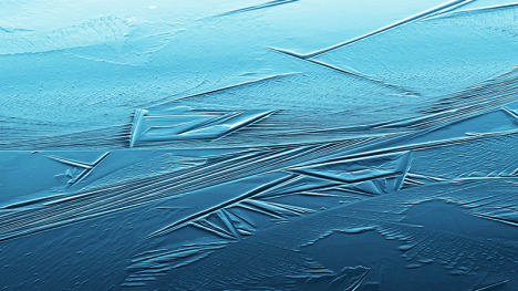 The surface of a lake which is just beginning to freeze.