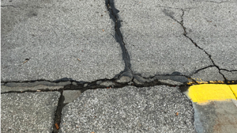Cracks in a road or parking lot that have been filled with tar and opened more.