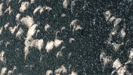 Crescent shaped sunlight shining on concrete