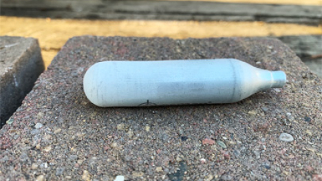 A carbon dioxide canister with frost on the outside.