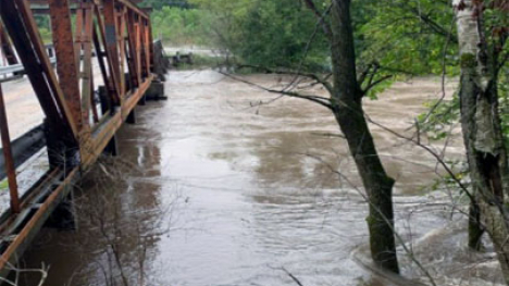 Flooding waterway passes under a bridge