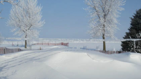 Image of snowy countryside with a snow fence.