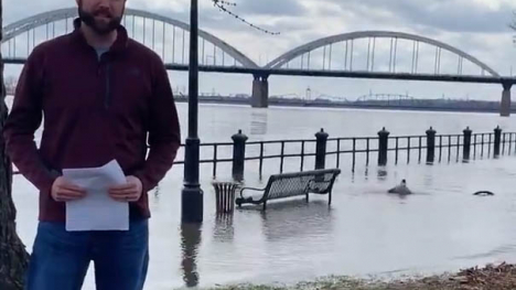 Image of man standing next to flooded Mississippi River.