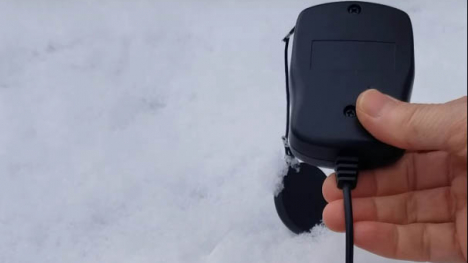 Image of person using light meter on snow.