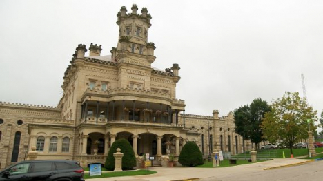 Historic stone building with a central tower, columns, and decorative details.