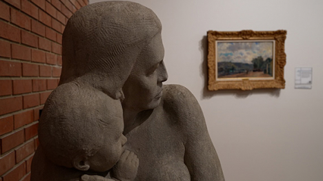 A stone sculpture of a woman holding a child.