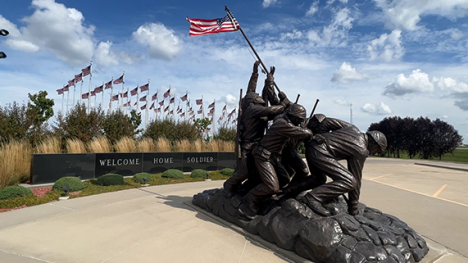 A sculpture of four soldiers planting the flag of the United States on a pole into the ground.